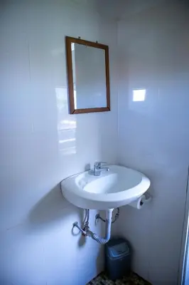 a white bathroom with a sink and a mirror at Alpin Guest House in Sapareva Banya