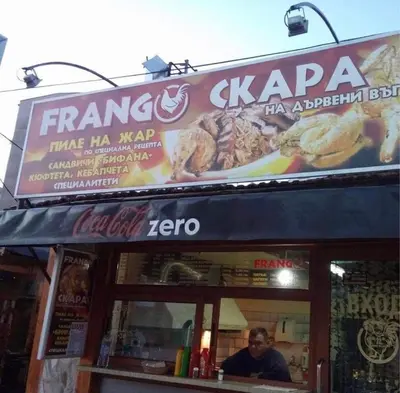 a man is sitting in front of a sandwich shop at Luxury apartment 1 Free Underground Secure Parking in Pazardzhik