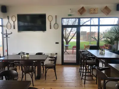 a restaurant with tables and chairs and a flat screen tv at Luxury apartment 1 Free Underground Secure Parking in Pazardzhik