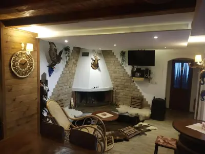 a living room with a fireplace and a chandelier at NIKI HOUSE in Bansko