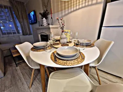 a dining room table with plates and glasses on it at 1 bedroom luxury apartment Milena -free parking in Pamporovo