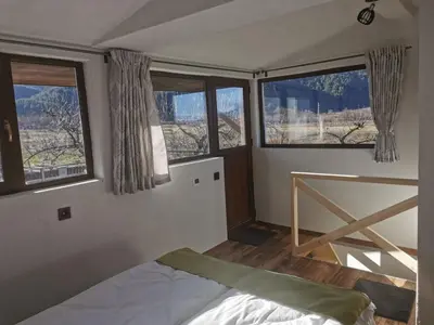 a bedroom with two windows and a bed in it at Ергини in Dobrinishte
