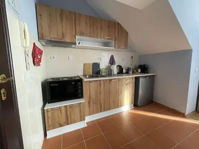 a small kitchen with wooden cabinets and a microwave at Your Place Borovets in Borovets