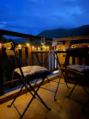 a balcony with wine glasses and a table and chairs at Your Place Borovets in Borovets