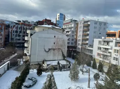 a building in a city with snow and buildings at Mila's 1 Bedroom Apartment in Sofia