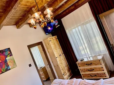 a bedroom with a bed and a chandelier at Villa ART in Dospat