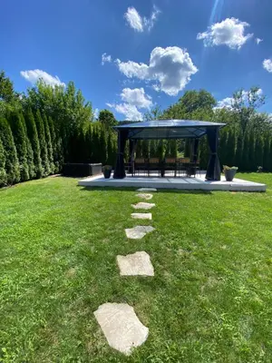 a garden with a gazebo and stepping stones in the grass at Luxury guests house “Heaven Hill”, Pravets city in Pravets
