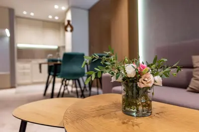 a vase filled with flowers sitting on a table at City Park Inn Apartment Verona in Plovdiv