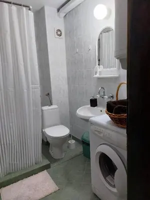 a bathroom with a toilet sink and a washing machine at Quiet central studio in Pazardzhik