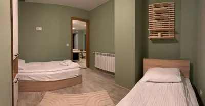 two beds in a room with green walls at Olive Apartment with terrace B100 in Grand Resort Pamporovo in Pamporovo