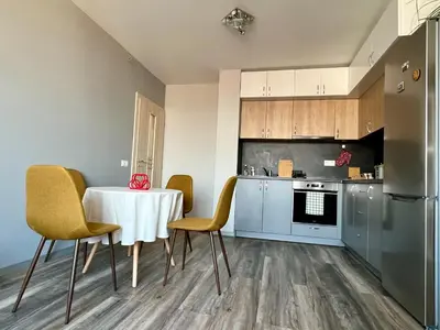 a kitchen with a table and chairs and a refrigerator at Habitat 29 Apartment in Sofia