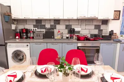 a kitchen with a table with red chairs and a kitchen with a counter at Vintage bohemian Paradise with Xbox Series X for BIG groups in Sofia