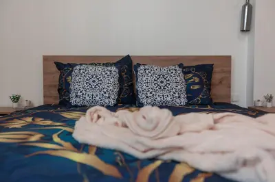 a bed with a blanket and pillows on it at Vintage bohemian Paradise with Xbox Series X for BIG groups in Sofia