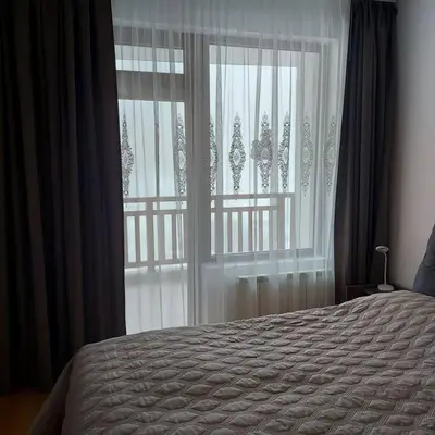 a bedroom with a bed and a large window at Семи гарден in Borovets