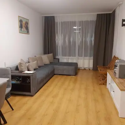 a living room with a couch and a wooden floor at Семи гарден in Borovets