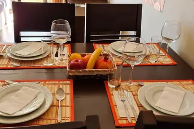 a table with plates and glasses and a basket of fruit at Apartment at Dream Bansko in Bansko