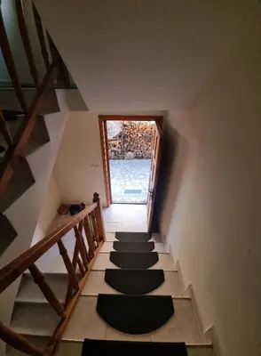 a stairway with black carpeted steps with a window at Банско Апартментс in Bansko