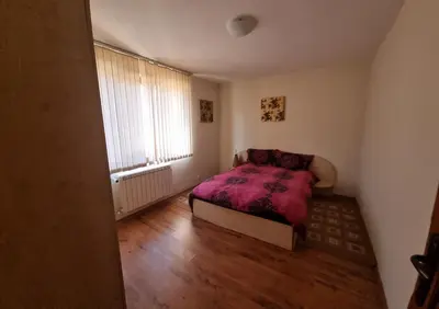 a bedroom with a bed with a purple blanket at Банско Апартментс in Bansko