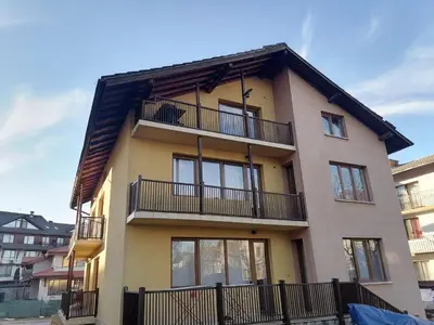 a building with balconies on the side of it at Банско Апартментс in Bansko
