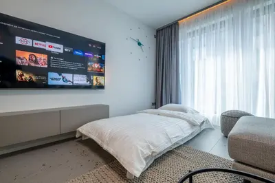 a bedroom with a bed and a tv on the wall at Emirates Luxury Apartment Free Parking Terrace in Sofia