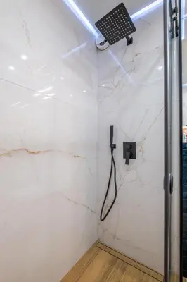 a shower in a bathroom with white marble walls at Emirates Luxury Apartment Free Parking Terrace in Sofia
