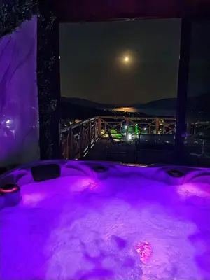 a jacuzzi tub with purple lighting on a balcony at Вилно селище PARADISE VIEW in Sarnitsa