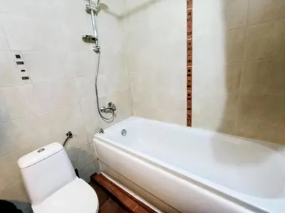 a bathroom with a white tub and a toilet at Diamond Heights apartament in Bansko