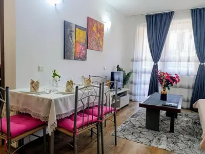 a dining room with a table and pink cushioned chairs at Diamond Heights apartament in Bansko