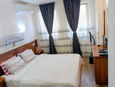 a bedroom with a bed and a window with curtains at Diamond Heights apartament in Bansko