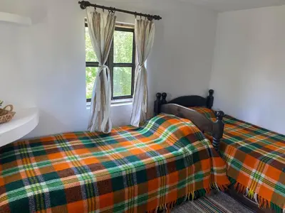 a bedroom with a bed and a window at Къща за гости НОВЕ in Terziysko