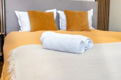 a stack of towels sitting on a bed at !!!1min From The Lift I Luxury Studio In Pirin Palace in Bansko
