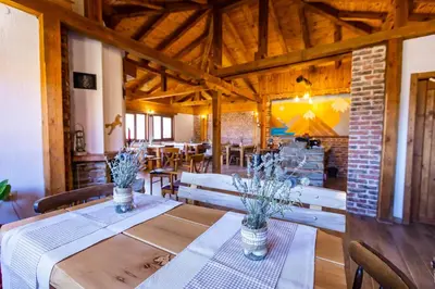 a dining room with wooden tables and chairs at Комплекс Конна база Асгард in Golem Tsalim