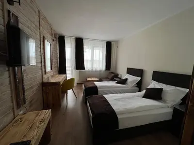 a hotel room with two beds and a television at Nicole Hotel & Restaurant in Samokov