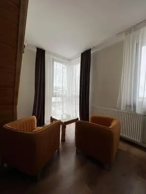 a living room with two chairs and a window at Nicole Hotel & Restaurant in Samokov