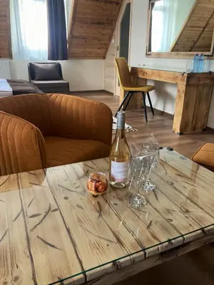 a bottle of wine and glasses on a wooden table at Nicole Hotel & Restaurant in Samokov