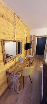 a room with a wooden wall with a table and a mirror at Nicole Hotel & Restaurant in Samokov