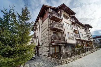 a large building with balconies on the side of it at Snow Legend Apartment with terrace in Bansko
