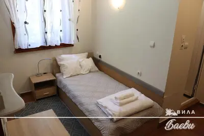 a small room with a bed with two pillows on it at ВИЛА БАЕВИ in Velingrad