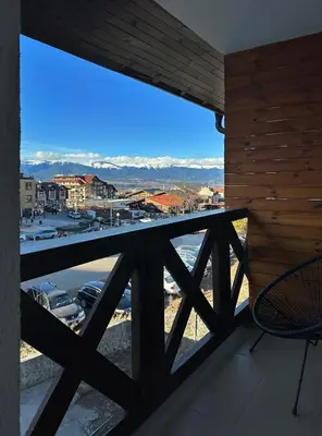 a room with a balcony with a view of a city at Apartment BonBon next to Gondola in Bansko
