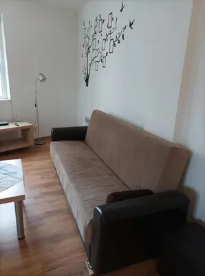 a living room with a brown couch and a table at Apartment 2 Detelina Residence in Bansko