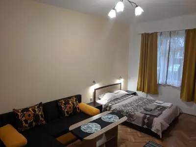 a living room with a couch and a bed at Convenient New Apartment Near Metro Station by Flat Mаnager in Sofia