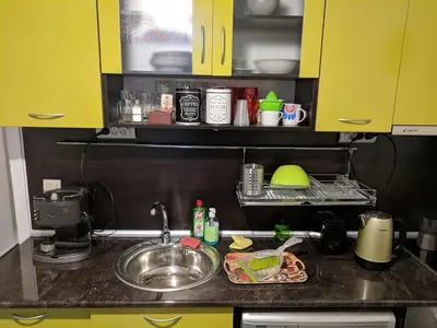 a kitchen counter with yellow cabinets and a sink at Convenient New Apartment Near Metro Station by Flat Mаnager in Sofia