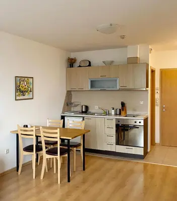 a kitchen with a table and chairs and a kitchen with a counter at Aspen studio Mountain retreat at Aspen Resort Golf Ski & Spa in Razlog