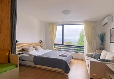 a bedroom with a bed and a large window at Aspen studio Mountain retreat at Aspen Resort Golf Ski & Spa in Razlog