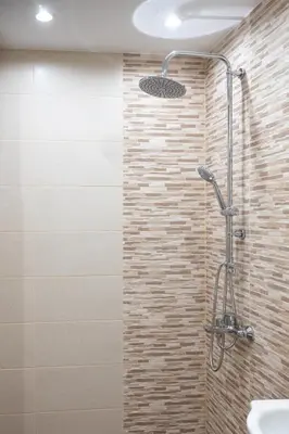 a shower in a bathroom with a stone wall at Modern and Cozy 1BDR Apartment in the City Center in Sofia