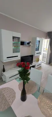 a living room with a glass table with a vase with roses at Luxury and stylish apartmen, metro station Obelya in Sofia
