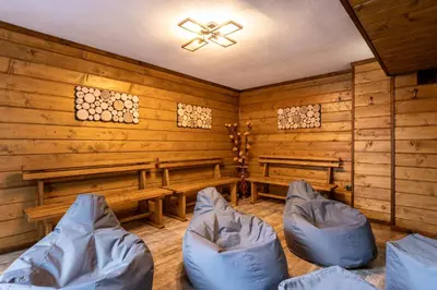 a room with benches and chairs in a cabin at Beluga Guest House in Velingrad