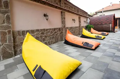 a group of yellow and orange pillows on a patio at Beluga Guest House in Velingrad
