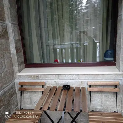 a wooden bench in front of a window at Borovets Gardens Studio Raya in Borovets