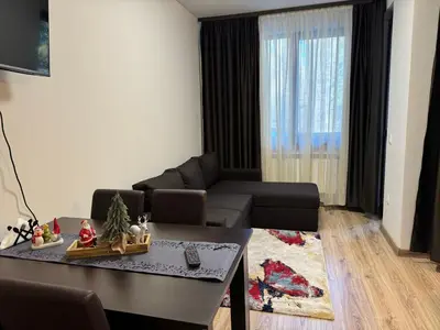 a living room with a couch and a table at Borovets Gardens Studio Raya in Borovets